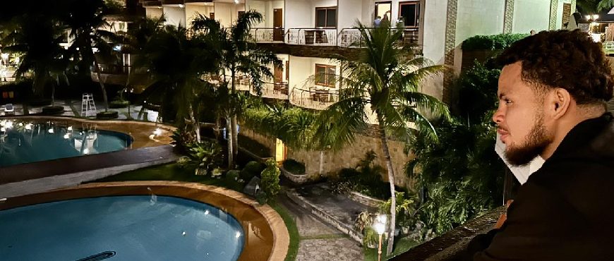 Stepping Curry at Bohol Tropics Resort in Tagbilaran, featuring illuminated swimming pools, palm trees, and resort buildings at night
