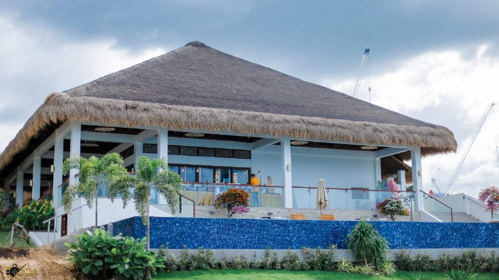 Casa Filomena Resort in Dauis, Bohol featuring a modern tropical pavilion with a thatched roof, open-air dining area, and blue infinity pool surrounded by lush greenery